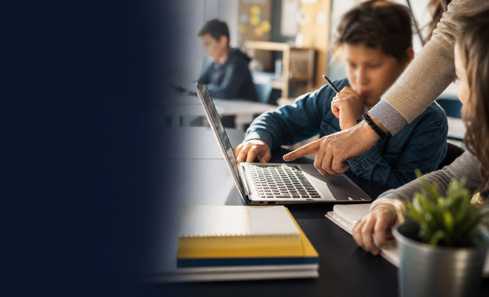 Students and a teacher working together around a laptop